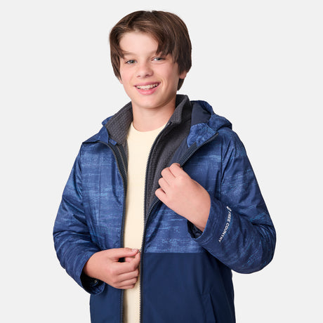 [River is wearing size M]Model in a two-tone blue Free Country 3-in-1 system jacket featuring zip-out fleece lining, rugged shoulder textures, and a smooth shell exterior; styled with a light base layer for adaptable, cold-weather comfort.