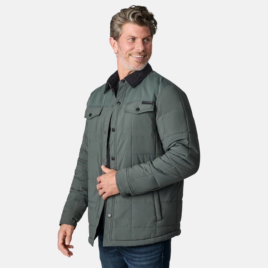[Kolby is 6'2" wearing size M.] Men’s Free Country green quilted jacket with black corduroy-style collar and button-up front—featuring dual flap chest pockets, angled side hand pockets, and a rugged outdoor look. Paired with dark pants for versatile, cold-weather styling.