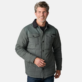 [Kolby is 6'2" wearing size M.] Men’s Free Country green quilted jacket with black corduroy-style collar and button-up front—featuring dual flap chest pockets, angled side hand pockets, and a rugged outdoor look. Paired with dark pants for versatile, cold-weather styling.