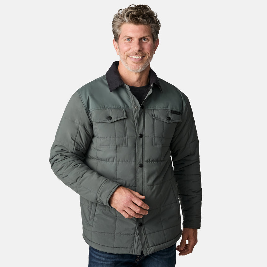 [Kolby is 6'2" wearing size M.] Men’s Free Country green quilted jacket with black corduroy-style collar and button-up front—featuring dual flap chest pockets, angled side hand pockets, and a rugged outdoor look. Paired with dark pants for versatile, cold-weather styling.