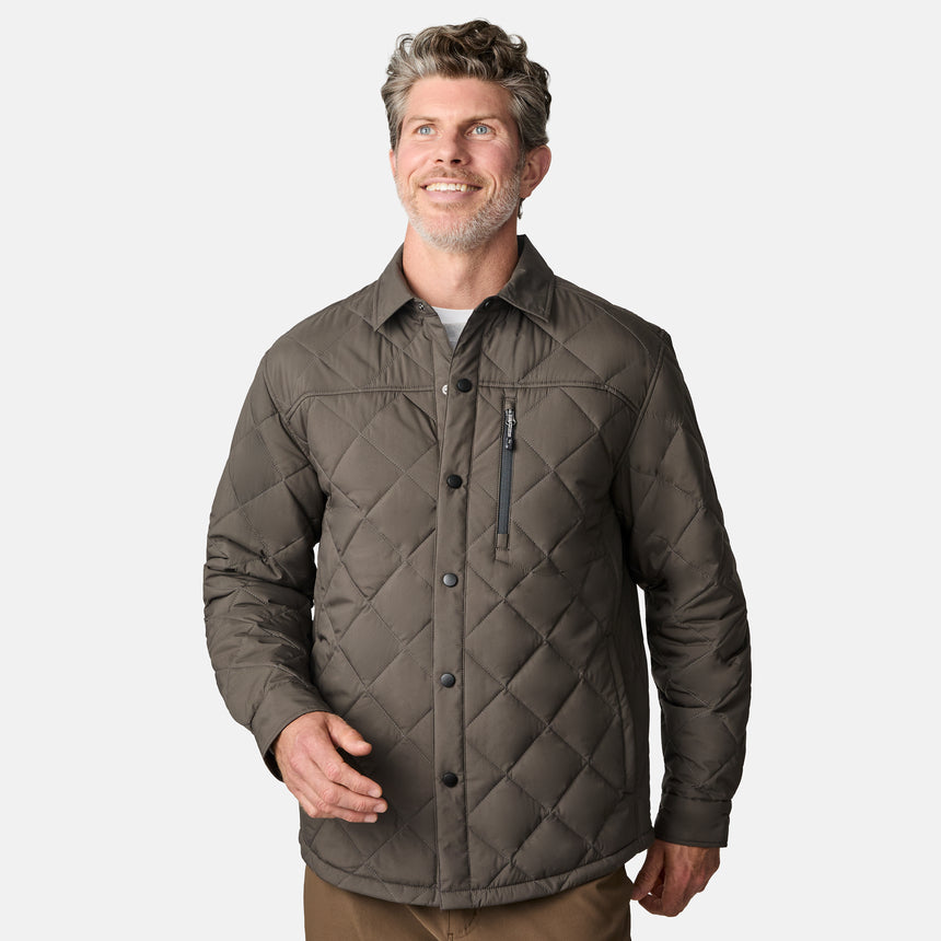 [Kolby is 6'2" wearing size M.] Men’s Free Country quilted jacket in brown with diamond pattern stitching—features a zippered left chest pocket, button front closure, and side hand pockets. Styled over a light gray shirt and paired with brown pants for a rugged, polished outdoor look.