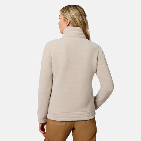 A woman shown from the back wearing a light beige fleece pullover sweater and brown pants against a clean white studio background.