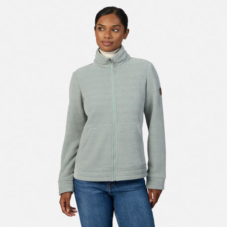 [Model is wearing size S.] A woman modeling a light gray heather zip-up fleece jacket with a mock neck collar, paired with blue jeans, against a plain light gray studio background.