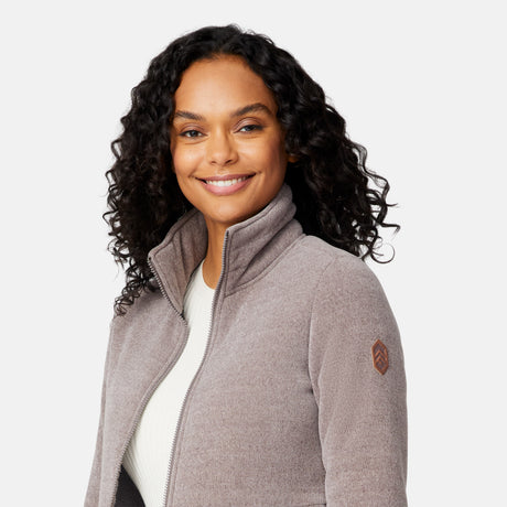 [Angelique is 5'10" wearing size S.] Women’s light brown zip-up jacket with high collar and textured finish, styled with two front pockets and paired with dark blue jeans against a plain white background.