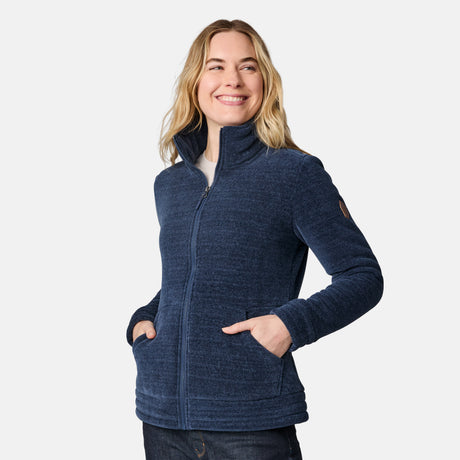 [CJ is 5'10" wearing size S.] Women’s dark blue zip-up fleece jacket with high collar, soft textured fabric, and dual front pockets—features a patch on the left sleeve and is styled with hands in pockets against a plain white background.