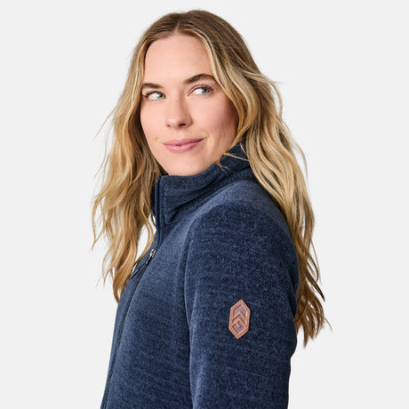 [CJ is 5'10" wearing size S.] Women’s dark blue zip-up fleece jacket with high collar, soft textured fabric, and dual front pockets—features a patch on the left sleeve and is styled with hands in pockets against a plain white background.