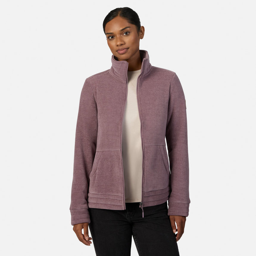 [Model is wearing size S.] A woman modeling a dusty mauve zip-up fleece jacket, paired with black pants and tan boots, against a plain light gray studio background.