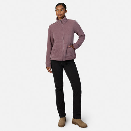 [Model is wearing size S.] A woman modeling a dusty mauve zip-up fleece jacket, paired with black pants and tan boots, against a plain light gray studio background.