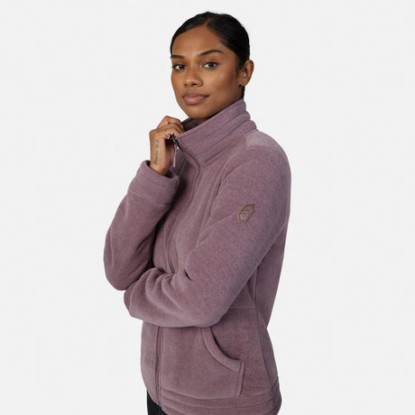 [Model is wearing size S.] A woman modeling a dusty mauve zip-up fleece jacket, paired with black pants and tan boots, against a plain light gray studio background.