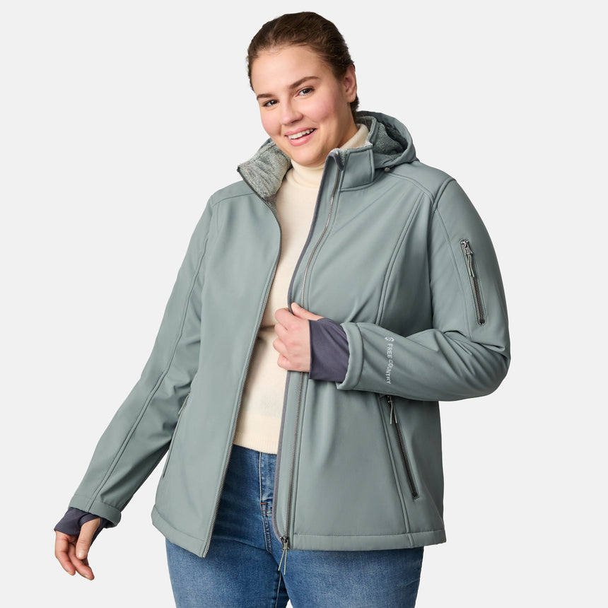 [Karissa is 5'9.5" wearing size 1X.] Light green hooded softshell jacket with zippered pockets on sides and sleeve; styled over blue jeans.