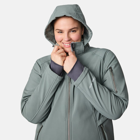 [Karissa is 5'9.5" wearing size 1X.] Light green hooded softshell jacket with zippered pockets on sides and sleeve; styled over blue jeans.
