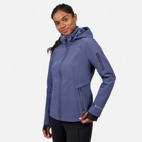[Model is wearing size S.] A woman wearing a slate blue hooded jacket with black zippers and black leggings, photographed against a light gray studio background.