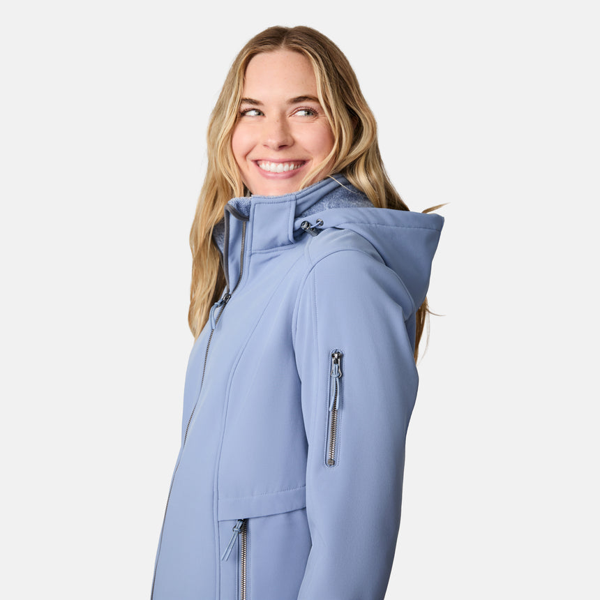 [CJ is 5'10" wearing size S.] Woman wearing a blue Free Country softshell jacket with a hood on a white background