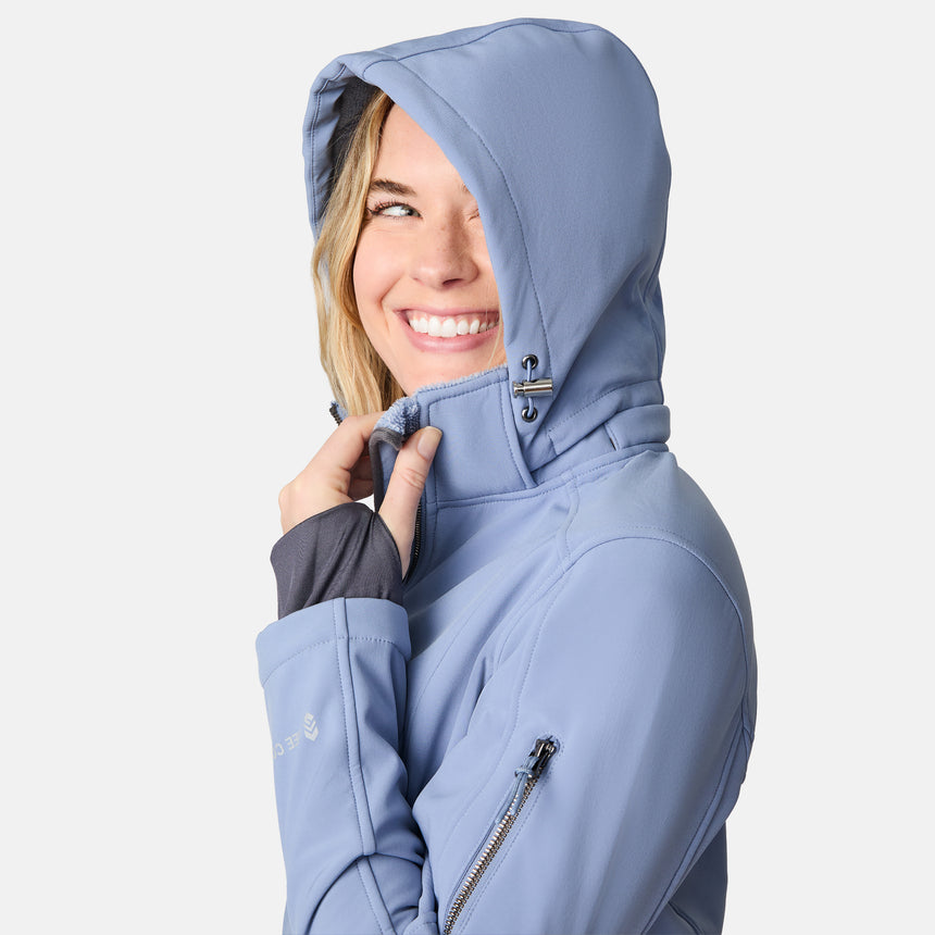 [CJ is 5'10" wearing size S.] Woman wearing a blue Free Country softshell jacket with a hood on a white background