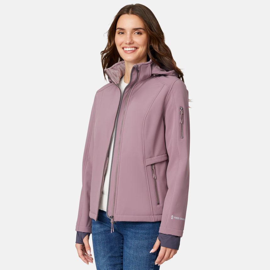 [Jessica is 5'9.5" wearing size S.] Woman wearing a purple Free Country softshell jacket with a hood on a white background