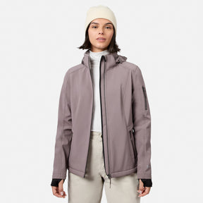 [Model is wearing size S.] A woman wearing a light dusty purple hooded jacket over a white turtleneck, paired with light beige pants and a cream beanie, standing against a solid light gray background.