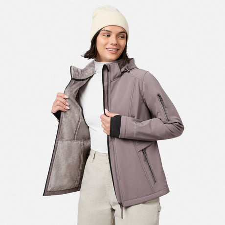 [Model is wearing size S.] A woman wearing a light taupe hooded jacket with black trim, a cream beanie, and light beige pants, shown against a plain light gray studio background.