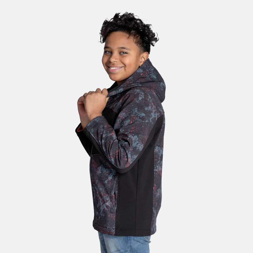 [Model is wearing size M.] Model wearing a red, black, and gray digital camo Free Country jacket featuring contrast side panels, zippered chest pocket, and full front zip; styled with denim for a bold, performance-ready outdoor look.