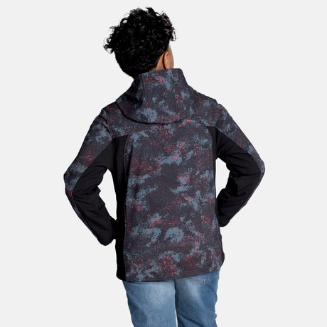 [Model is wearing size M.] Model wearing a red, black, and gray digital camo Free Country jacket featuring contrast side panels, zippered chest pocket, and full front zip; styled with denim for a bold, performance-ready outdoor look.