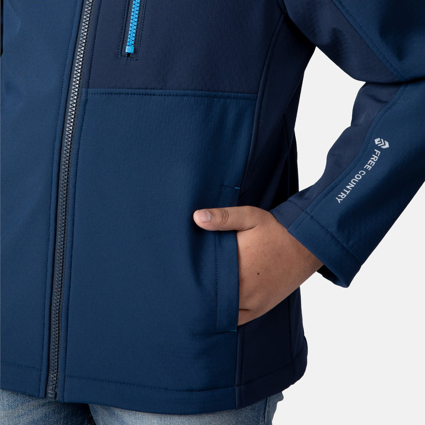 [Model is wearing size M.] Model wearing a blue Free Country softshell jacket with a contrast zippered chest pocket and side-entry hand pockets; lightweight water-resistant construction with an active fit, ideal for transitional weather and casual outdoor wear.
