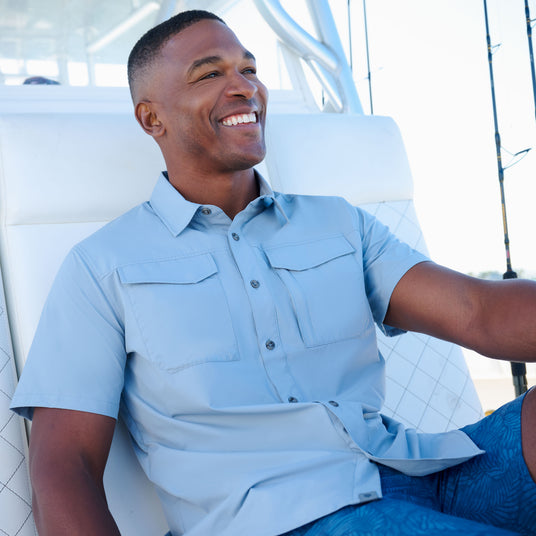 Man wearing a light blue shirt sitting on a boat