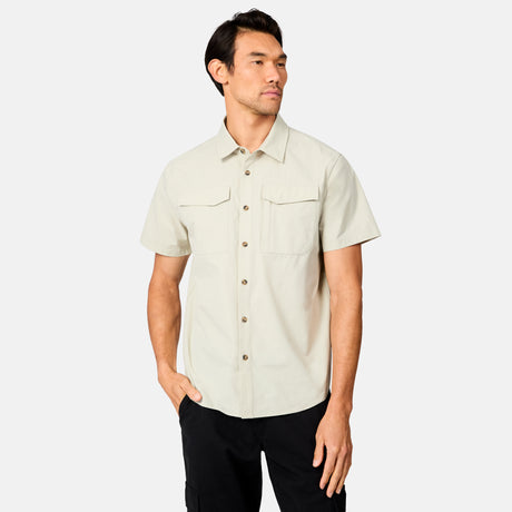 [Scott is 6’3 wearing size M] Man wearing a tan short-sleeve button up shirt on a white background