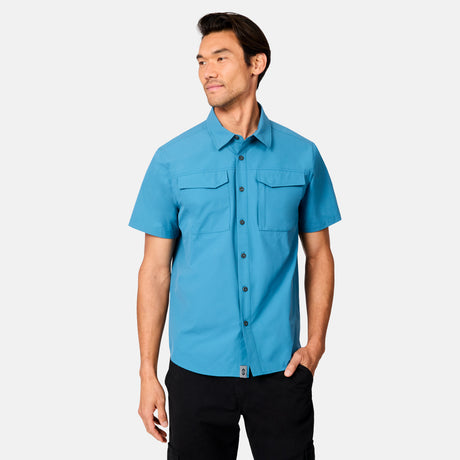 [Scott is 6’3 wearing size M] Man wearing a blue short-sleeve button up shirt on a white background
