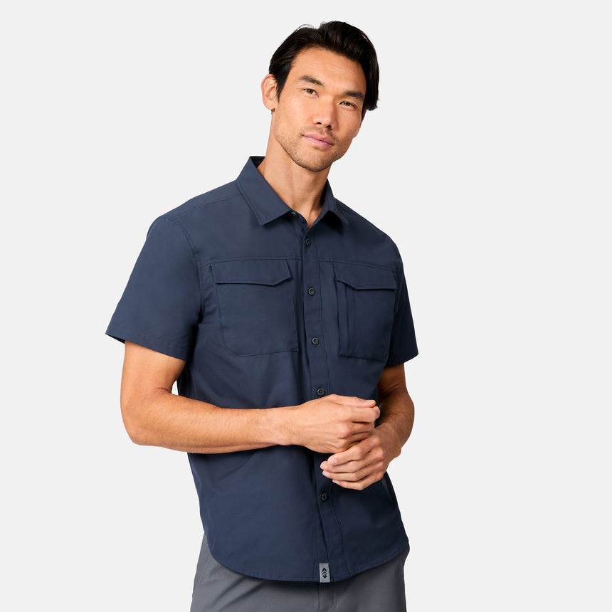 [Scott is 6’3 wearing size M] Man wearing a navy blue short-sleeve button up shirt on a white background