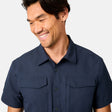 [Scott is 6’3 wearing size M] Man wearing a navy blue short-sleeve button up shirt on a white background