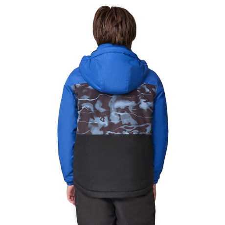 A person with brown hair is seen from behind, wearing the Free Country Boys' Out of Bound Boarder Jacket—a blue, water-resistant, hooded jacket featuring a black and gray camo back and black lower section—paired with black pants.