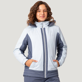 [Model is wearing a size Medium.] Girl wearing the Free Country Girls' Boarder Jacket in light blue and navy, featuring Butter Pile® lining, a wind- and water-resistant shell, and a hooded design, paired with matching navy snow pants.