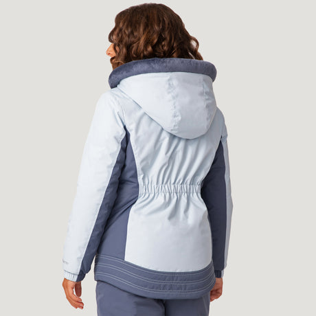 [Model is wearing a size Medium.] Girl wearing the Free Country Girls' Boarder Jacket in light blue and navy, featuring Butter Pile® lining, a wind- and water-resistant shell, and a hooded design, paired with matching navy snow pants.