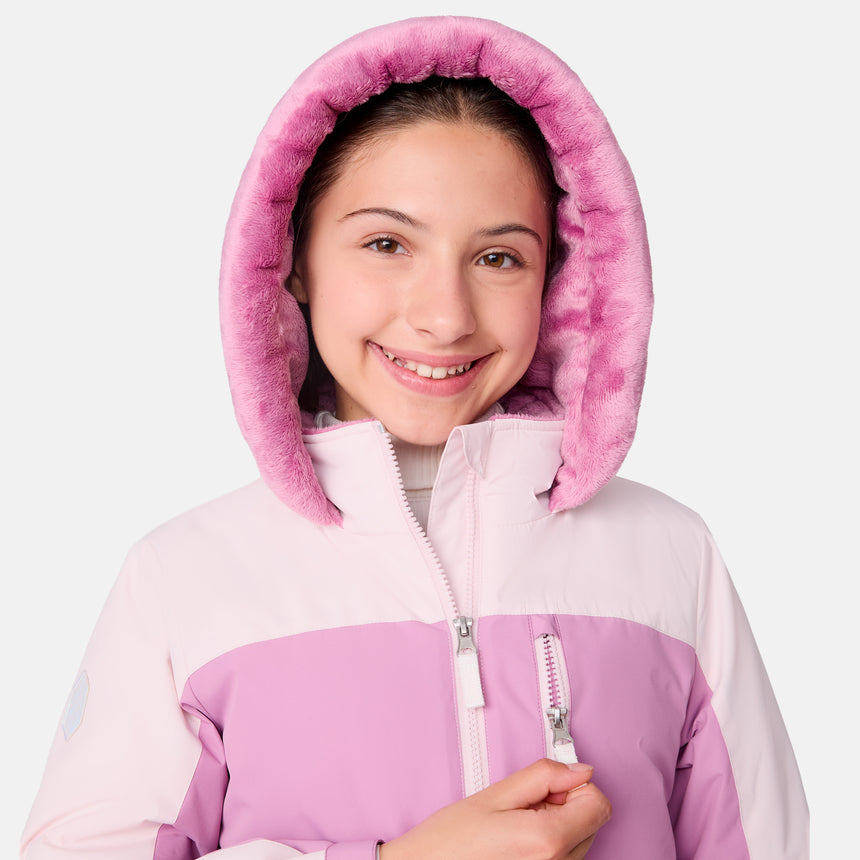 [Samantha is wearing size M.] Model wearing a Free Country color-blocked winter jacket in pink and navy, featuring a fuzzy-lined hood, zippered chest and hand pockets, and insulated design for cold-weather comfort. Paired with matching navy snow pants for outdoor adventures.
