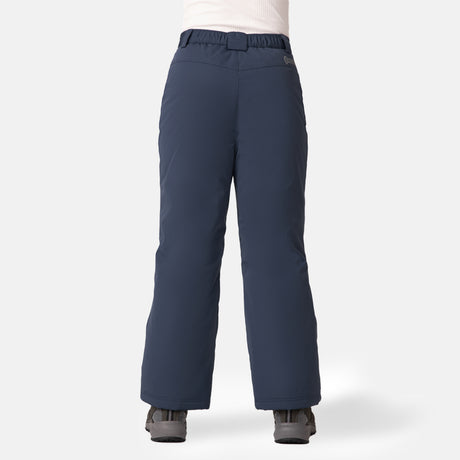 A child wears Free Country Kids' Padded Ski Pant in navy blue, featuring water resistance and snow gaiters, with gray boots, standing back to the camera against a plain white background.