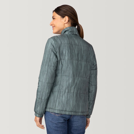 [Olga is 5’9” wearing a size Small.] Woman wearing Free Country Women's Back of Bell 3-in-1 Systems Jacket in light blue with a full front zipper opening, soft lining, attached hood with adjustable drawcords, and water resistant and wind resistant stretch performance fabric, inner puffer jacket, outer shell for weather, light grey background. Perfect women’s  jacket for fall weather.