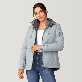 [Olga is 5’9” wearing a size Small.] Woman wearing Free Country Women's Back of Bell 3-in-1 Systems Jacket in light blue with a full front zipper opening, soft lining, attached hood with adjustable drawcords, and water resistant and wind resistant stretch performance fabric, inner puffer jacket, outer shell for weather, light grey background. Perfect women’s  jacket for fall weather.