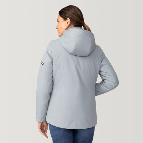 [Olga is 5’9” wearing a size Small.] Woman wearing Free Country Women's Back of Bell 3-in-1 Systems Jacket in light blue with a full front zipper opening, soft lining, attached hood with adjustable drawcords, and water resistant and wind resistant stretch performance fabric, inner puffer jacket, outer shell for weather, light grey background. Perfect women’s  jacket for fall weather.