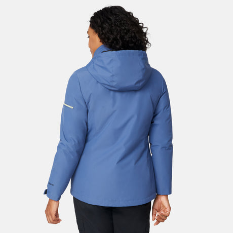 A person with curly hair, seen from behind, wears the Free Country Women's Back of Bell 3-in-1 Systems Jacket in blue and black pants against a plain white background.