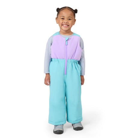 A young child wearing a colorful zip-up snowsuit with a lavender chest panel, light blue lower body, and gray sleeves, standing against a plain white background.