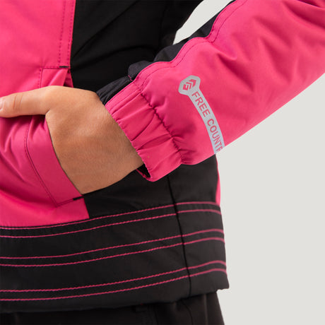 [Model is wearing a size Medium.] Girl wearing the Free Country Girls' Boarder Jacket in bright pink and black, featuring Butter Pile® lining, a wind- and water-resistant shell, and a hooded design.