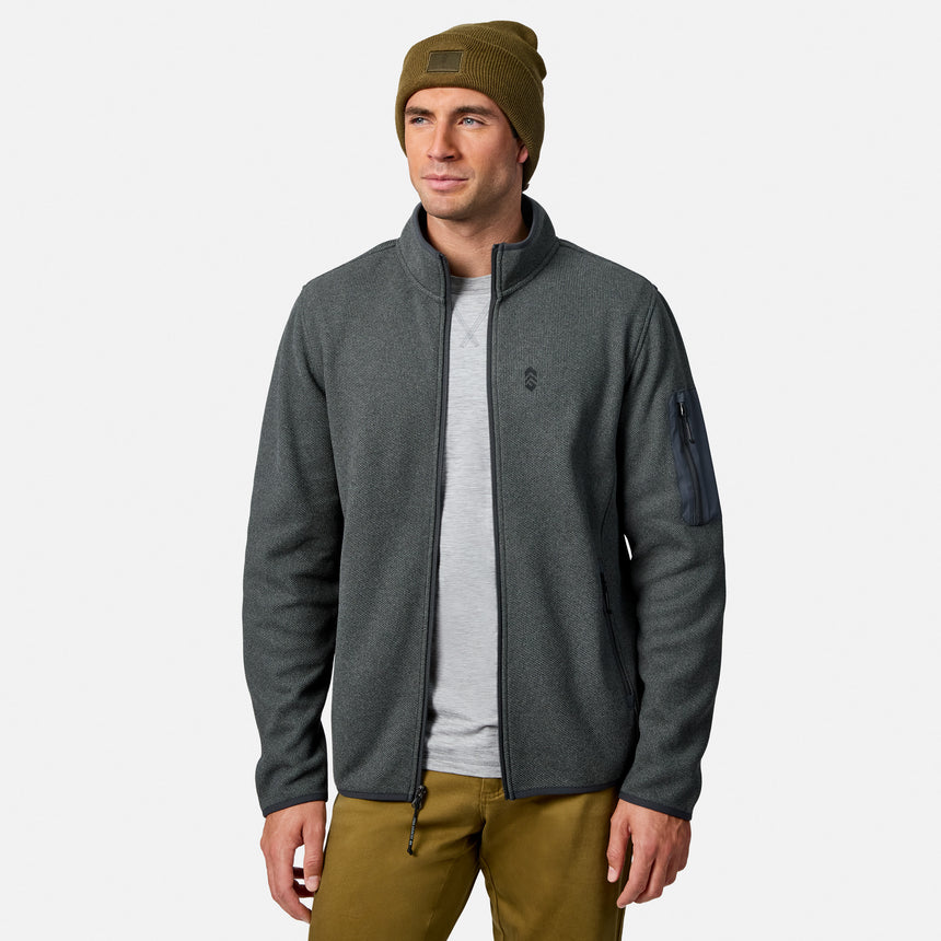 [Model is wearing size M.] A man wearing a dark gray zip-up fleece jacket, olive green beanie, gray t-shirt, and olive pants, standing against a light gray background.