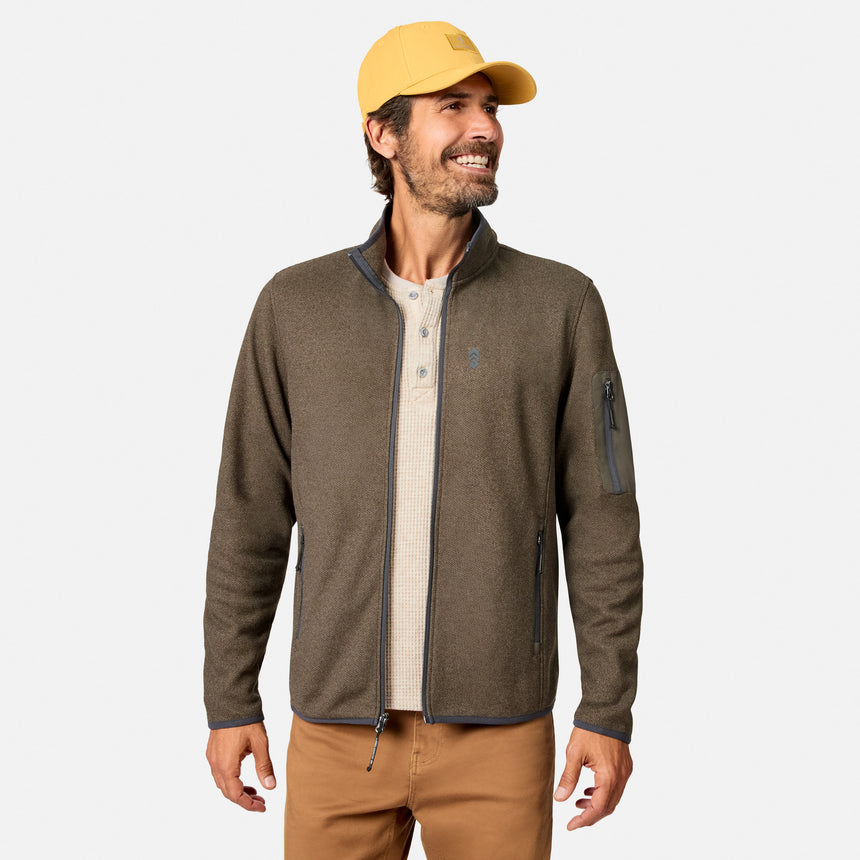 [Model is wearing size M.] A man wearing a brown zip-up fleece jacket, a yellow baseball cap, and tan pants, standing against a light gray studio background.