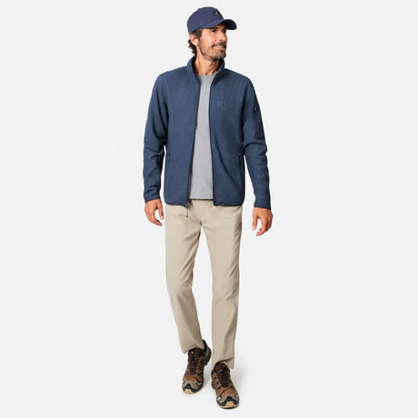 [Model is wearing size M.] A man modeling a navy blue quarter-zip fleece jacket, worn over a gray t-shirt with beige pants and brown hiking boots, on a light gray background.