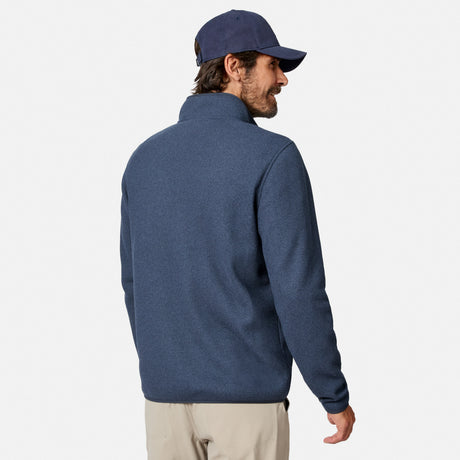 [Model is wearing size M.] A man wearing a navy blue quarter-zip fleece pullover and a matching navy baseball cap, shown from a three-quarters back view against a light gray studio background.