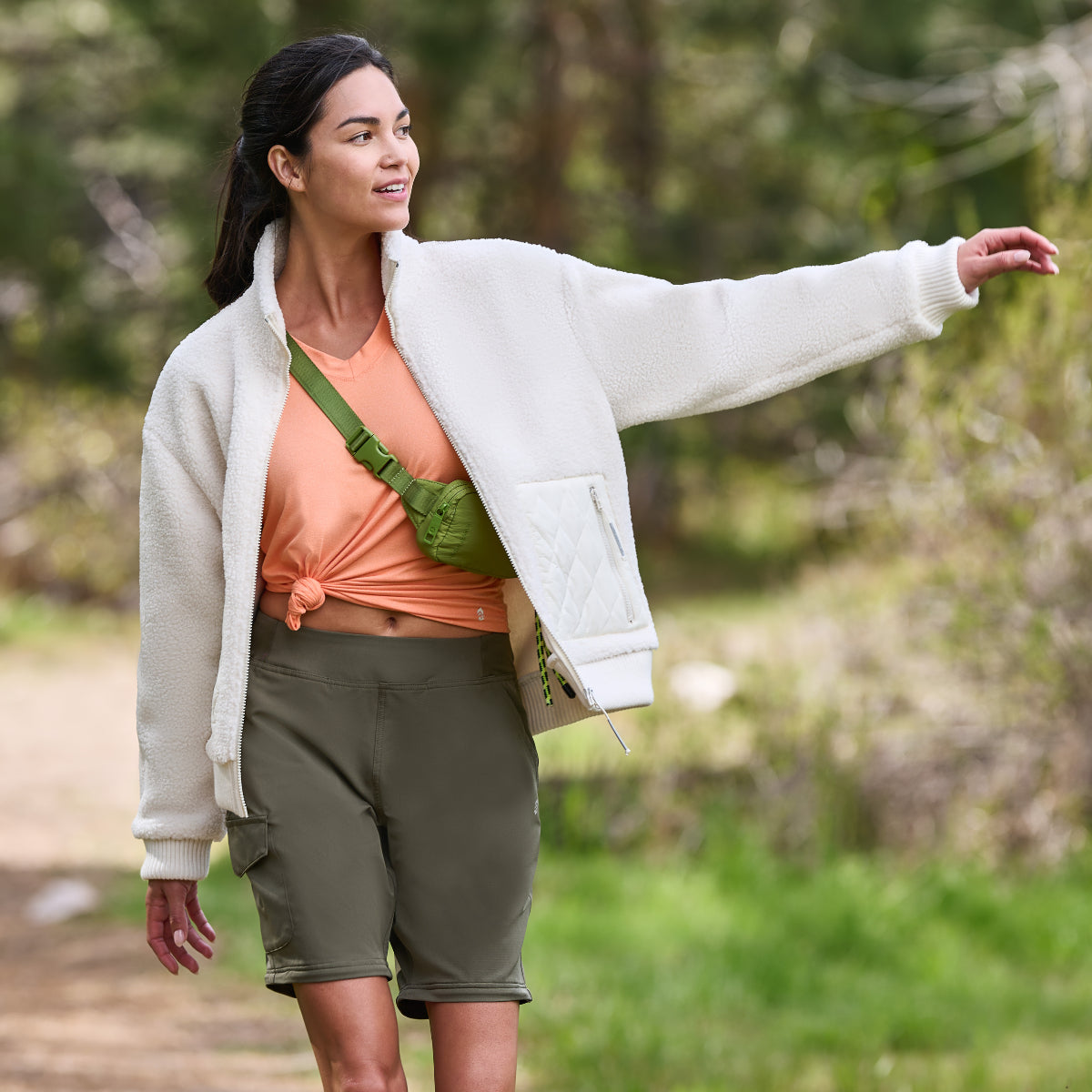 Woman walking a trail in a white quilted-panel fleece jacket