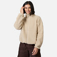 [Model is wearing size S.] A woman wearing a beige sherpa fleece zip-up jacket and dark brown cargo pants, standing against a light gray studio background.