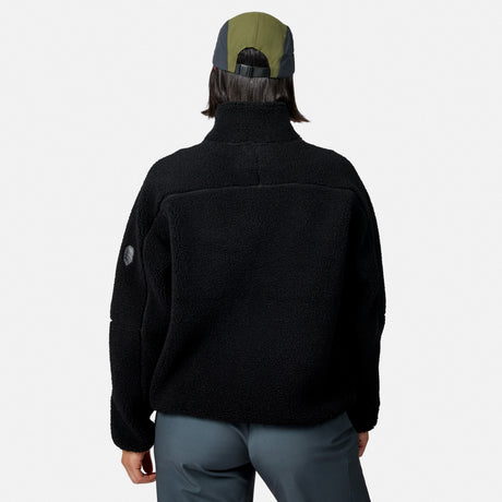 [Model is wearing size S.] A person shown from the back wearing a black fleece quarter-zip jacket, gray pants, and a green and gray baseball cap against a light gray studio background.