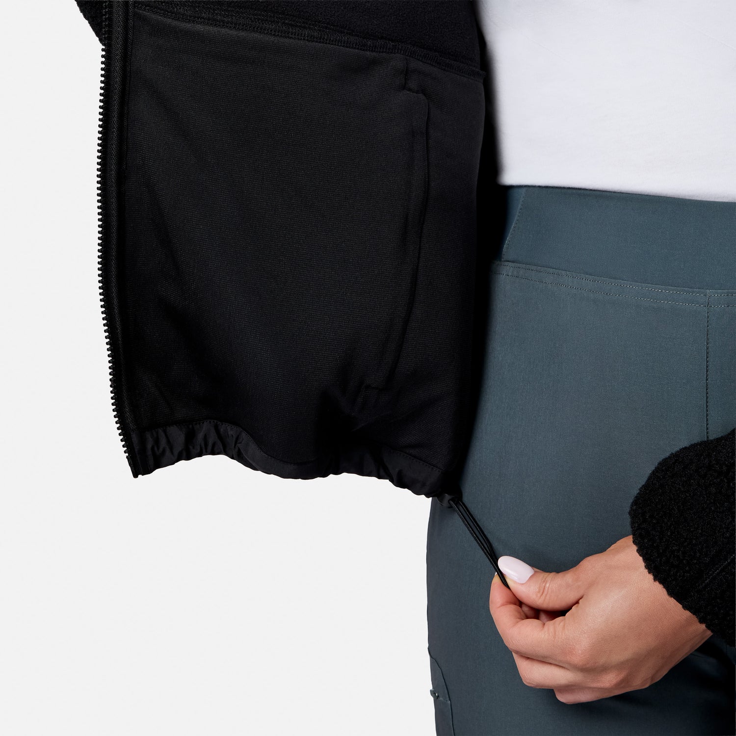 [Model is wearing size S.] Close-up of a person wearing black zippered shorts or a skirt and slate blue-gray athletic pants, with a hand pulling the zipper tab.