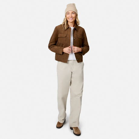 [Model is wearing size S.] A woman modeling a brown cropped utility jacket, beige pants, a beige beanie, and brown shoes against a light gray studio background.