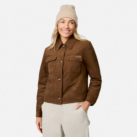 [Model is wearing size S.] A woman wearing a brown suede-like button-front jacket with chest flap pockets, a beige beanie, and light beige pants, photographed against a clean light gray studio background.
